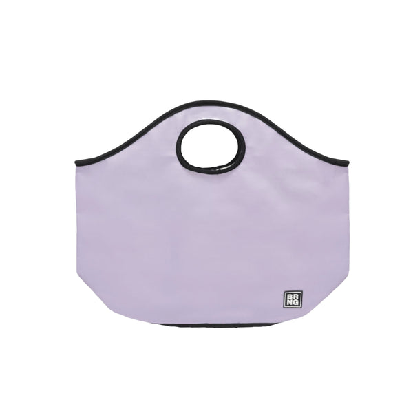 The Brooke Tote by BRNG Bag is a light lavender flat bottom tote featuring black trim, a circular top handle, and a small black and white square logo on the bottom right corner.