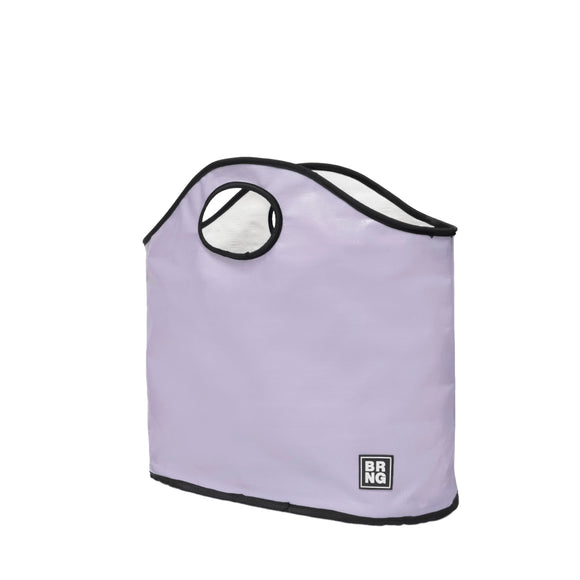 The Brooke Tote by BRNG Bag is a light purple bag with black trim, a round handle cutout, and a small BRNG logo patch on the lower right. This lavender tote features a soft rectangular shape, roomy flat bottom, and stands upright.